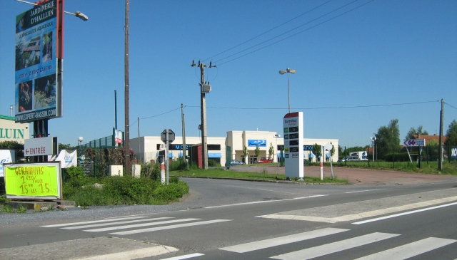 a french street with supermarket, crossing and billboards